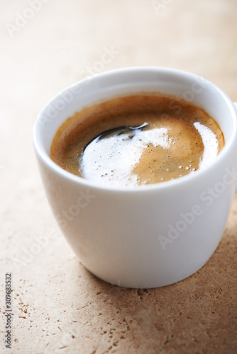 Cup of coffee on bright stone background. Close up.