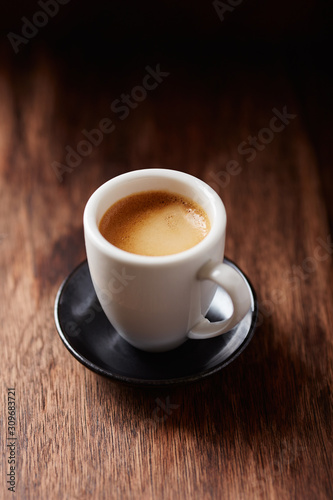 Cup of coffee on brown wooden background. Close up.