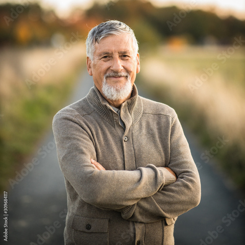 Portrait of handsome senior man in the autumn outdoors. Active senioor enjoying his retirement in the  nature photo