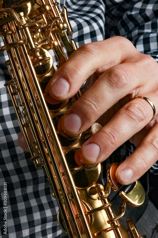 Fototapeta premium soprano saxophone in hands on a black background