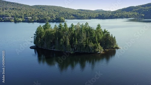 Aerial flying over a calm lake with an island in the middle.  Lac Superieur, Mont Tremblant, Quebec, Canada photo