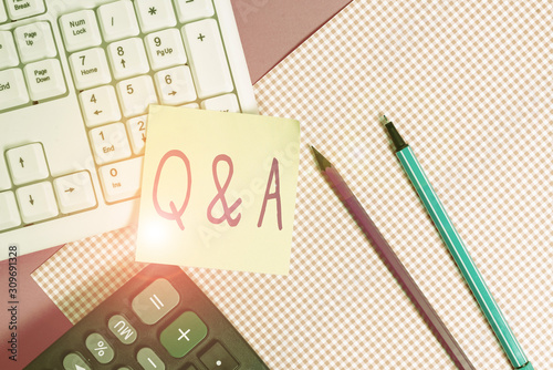Writing note showing Q And A. Business concept for in which demonstrating asks questions and another one answers them Note paper stick to keyboard near colored gift wrap on table