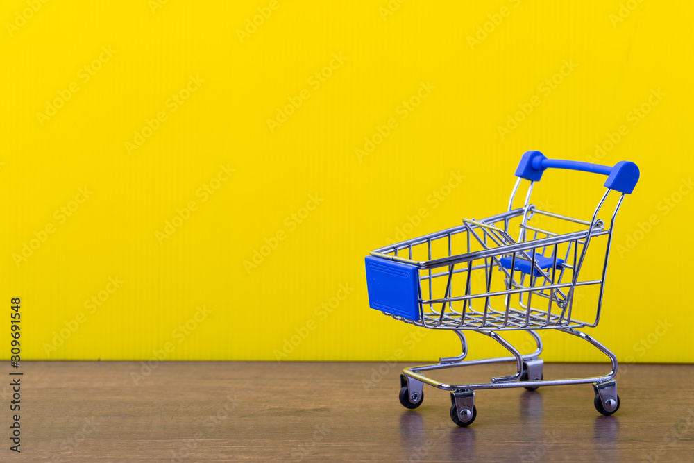 shopping trolley cart on yellow background.