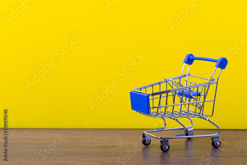 shopping trolley cart on yellow background.