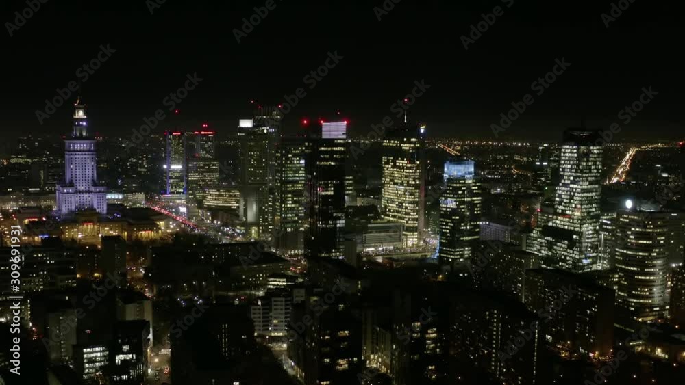 Aerial view of the night city with skyscrapers and busy streets with traffic jams during rush hour. Warsaw, Poland. 13. December. 2019. Drone shot at night metropolis with skyscrapers and buildings.