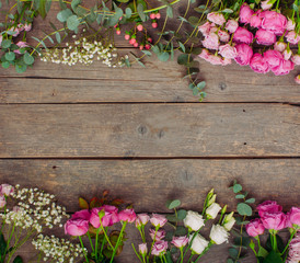 Frame of flowers on rustic wooden background with copy space