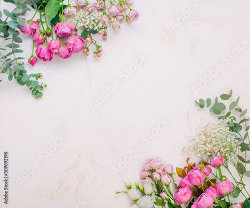 Frame of flowers on white marble background with copy space