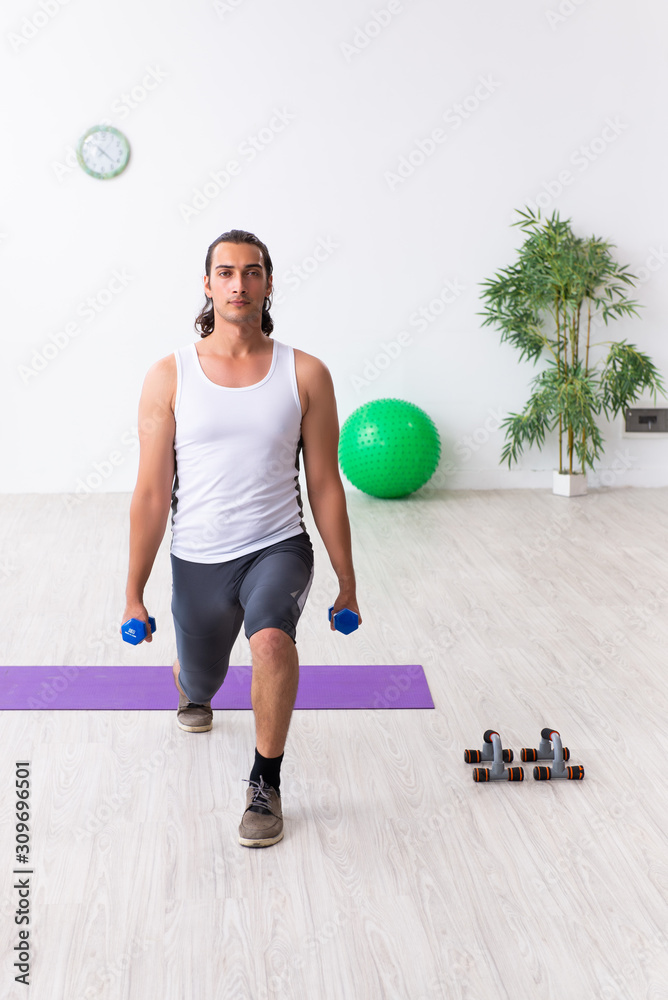 Young handsome man doing sport exercises indoors Young handsome man doing sport exercises indoors