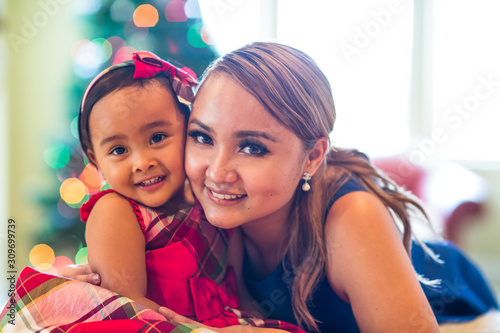 Mother and young daughter pose for a Christmas photo