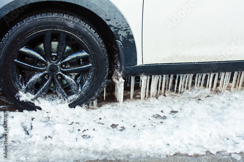 close up photo off car in iciles, a lot of water and snow, seasonal issues concept photo