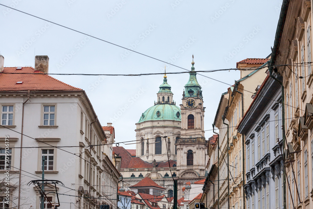 St Nicholas Church, also called Kostel Svateho Mikulase, in Prague, Czech Republic, with its iconic dome seen from nearby streets with typical baroque facade. It's one of main landmarks