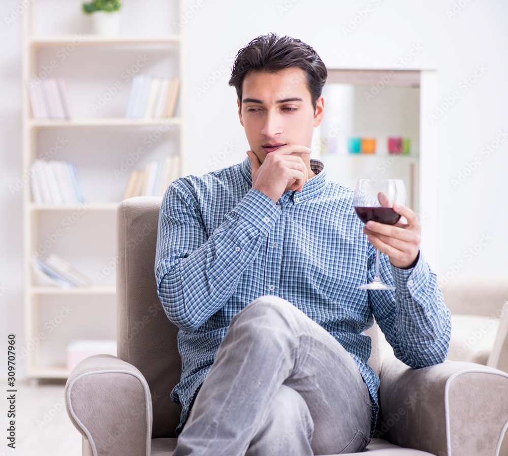 Young man drinking wine at home Young man drinking wine at home