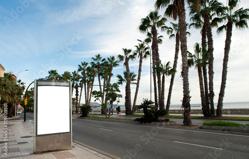 billboard in the city center with palm trees in the background and blue sky