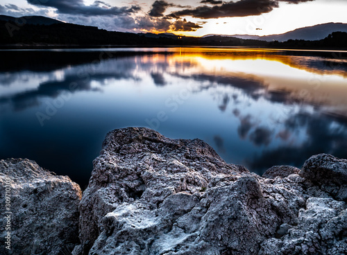 sunset with reflections in the water from the reservoir of beniarres, Alicante photo