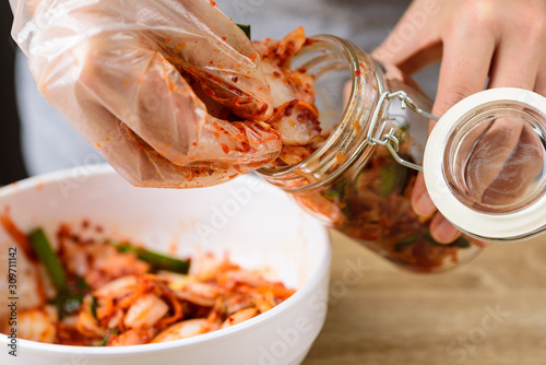 Kimchi cabbage cooking in bowl and fermentating in jar, homemade Korean food photo