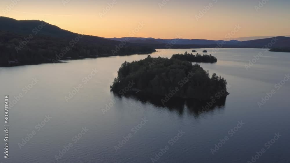 Aerial: Forest & calm tranquil Ouareau Lake at sunset. Islands are scattered throughout the lake. Laurentian Mountains near Montreal, Quebec, Canada Aerial: Forest & calm tranquil Ouareau Lake at sunset. Islands are scattered throughout the lake. Laurentian Mountains near Montreal, Quebec, Canada