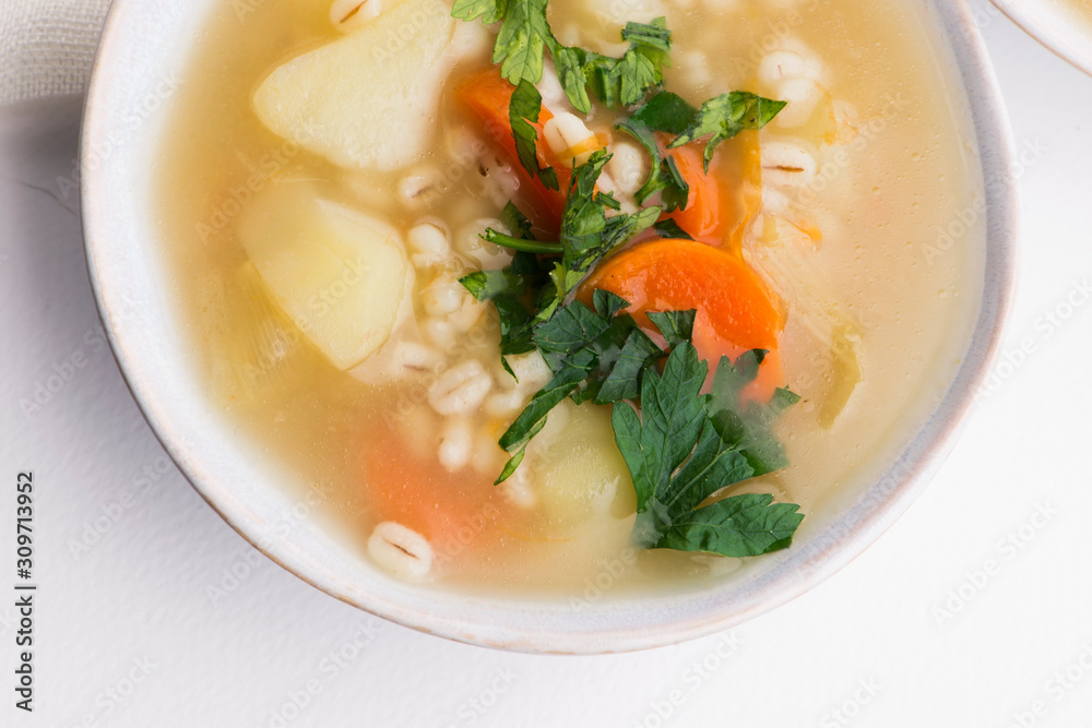 Barley soup, pearl barley in white bowl Barley soup, pearl barley in white bowl