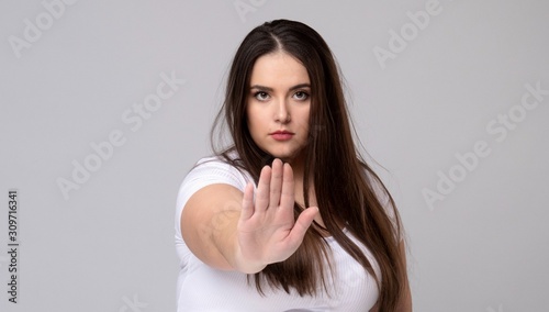 Plus Size Model with long hair gesturing no signal in studio.