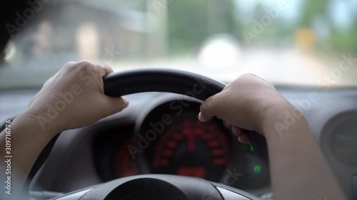 man driving car in day time, hand on steering wheel, shallow depth of field.