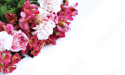 Festive floral arrangement in bright colors. Purple, pink and red flowers on a white background. Roses, peonies and ectromelia in an elegant bouquet on a white background. Background for greetings, in photo