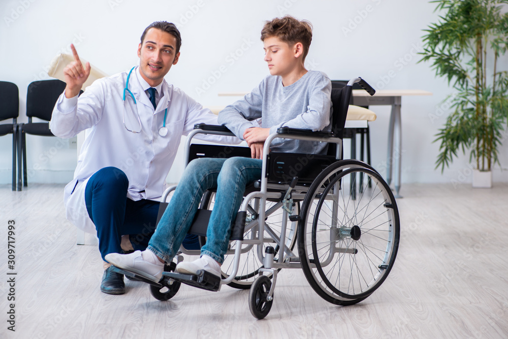 Young male doctor pediatrist and boy in wheel-chair Young male doctor pediatrist and boy in wheel-chair