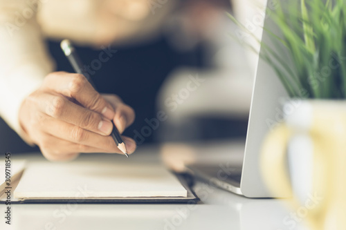 Wallpaper Mural Close up of male hand writing with pencil on the book. Businessman working with data information in the office. Torontodigital.ca