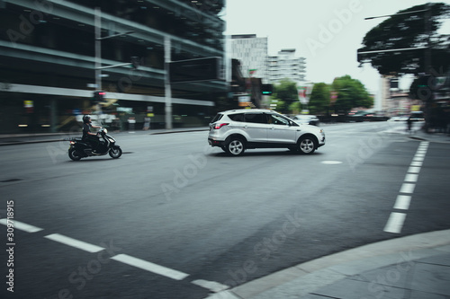Car and motor cycle travelling around a corner with motion blur effect in the background © Southern Creative