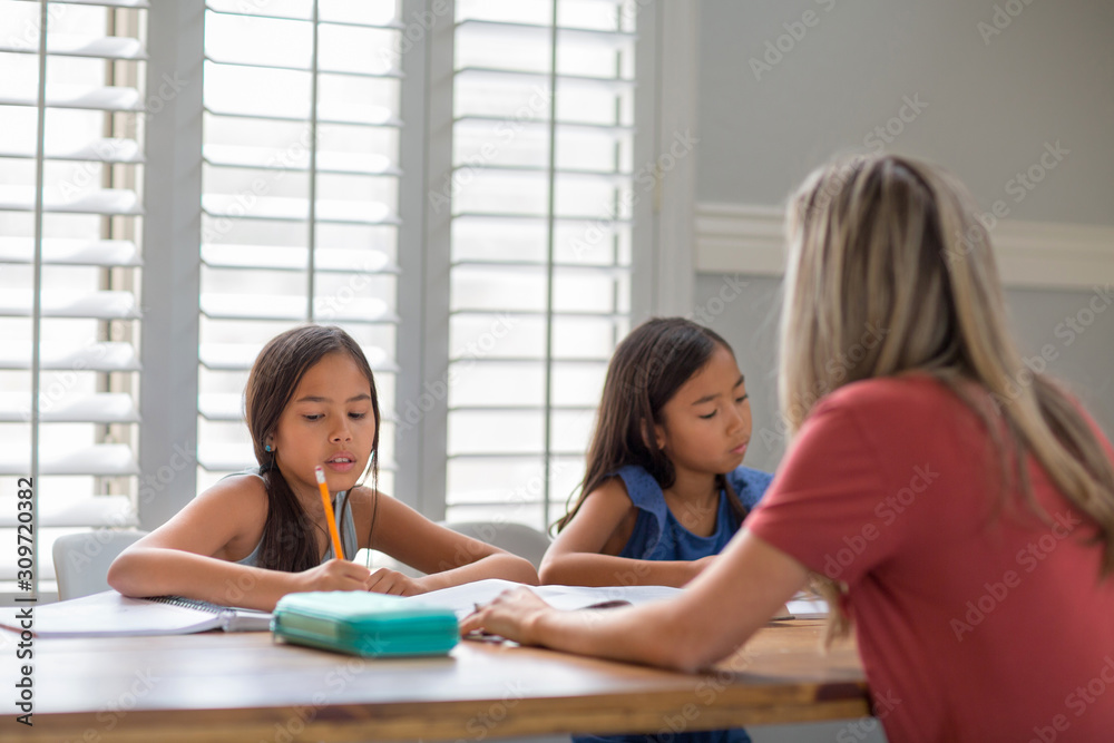Mother Helping Her Daughters With Their Homework Mother Helping Her Daughters With Their Homework