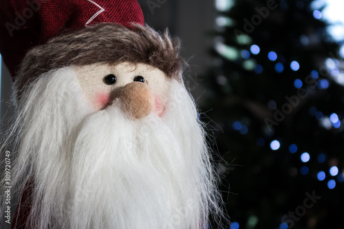 cloth Santa Calus's puppet against the background of Christmas tree