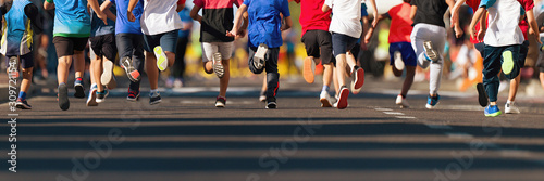 Running children, young athletes run in a kids run race,running on city road detail on legs