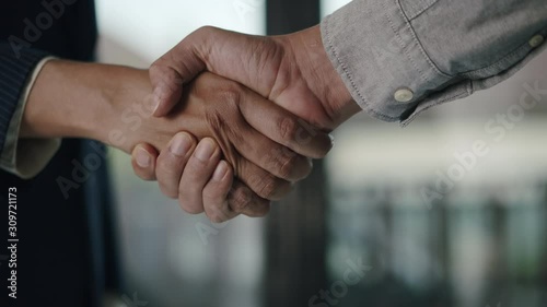 Close up. Hand of two Asian business people gathered to handshake agree to a deal or say hello in the office