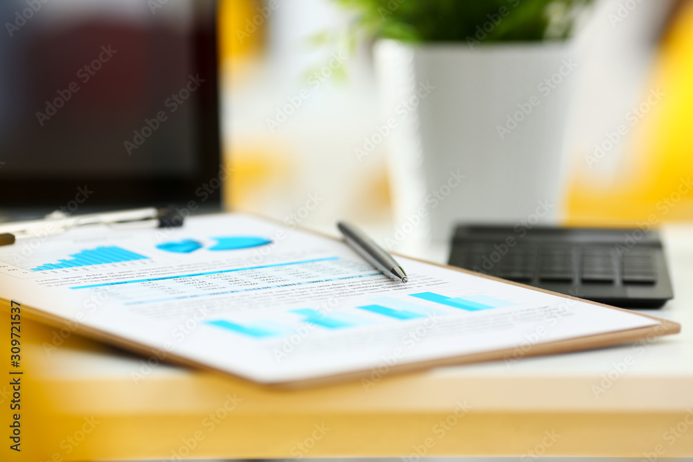 Silver pen lying on important stats paper clipped to pad Silver pen lying on important stats paper clipped to pad
