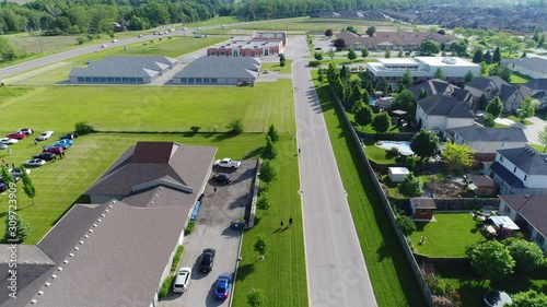 People Walking Down Road With Houses And Storage Units Summer Day Aerial photo