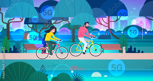 couple riding bicycles in public park 5G online wireless system connection concept man woman cycling outdoors horizontal full length vector illustration