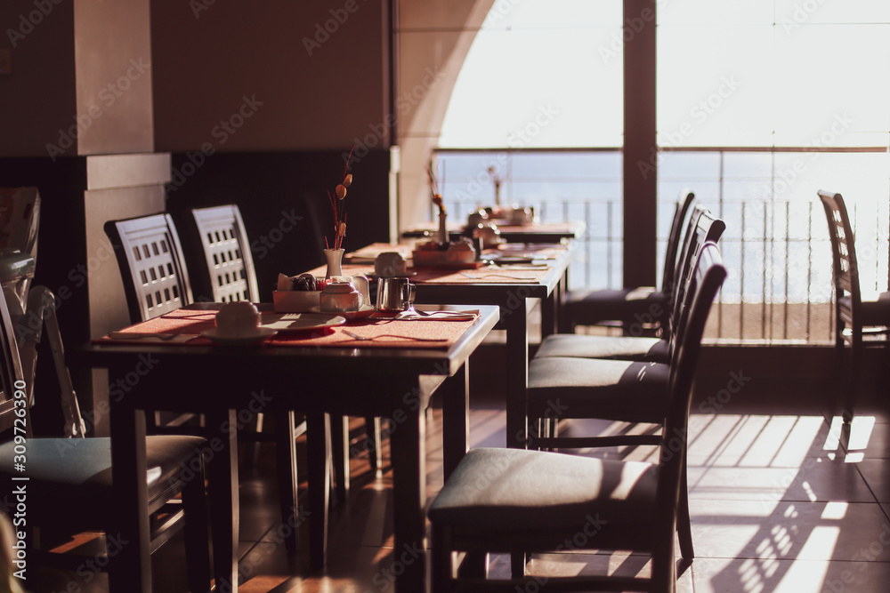 Shallow depth of field (selective focus) image with tables in a restaurant at breakfast early in the morning Shallow depth of field (selective focus) image with tables in a restaurant at breakfast early in the morning
