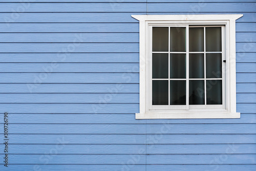 White frame window on blue wooden wall with copy space.