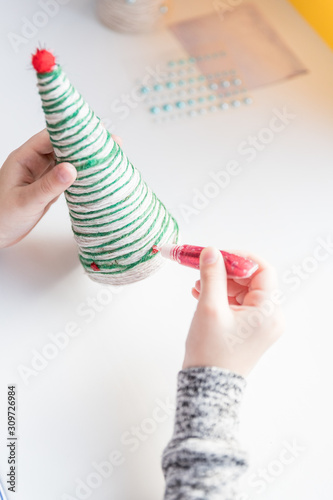 Making Christmas tree . Original children's art project. DIY concept. Step-by-step,instructions. Selective focus.Making xmas toys decoration. Merry Christmas and Happy New Year decoration. Handmade