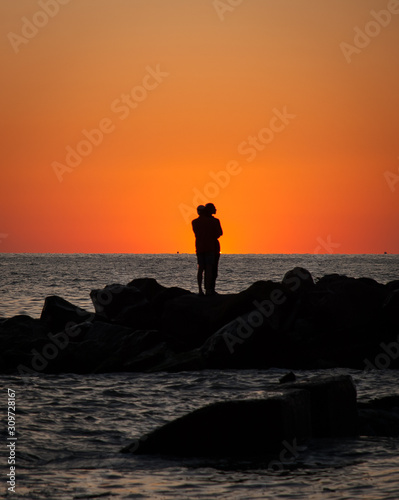 The romantic scene of the pair at sunset on the seashore
