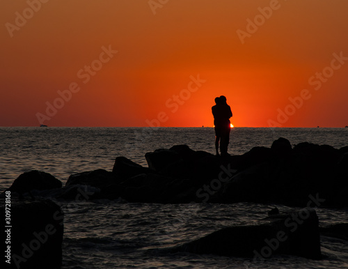 The romantic scene of the pair at sunset on the seashore