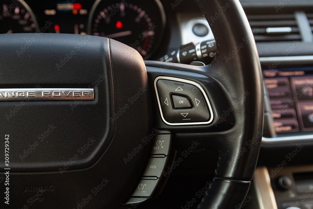 View to the interior of Land Rover Evoque with dashboard, steering wheel with buttons after