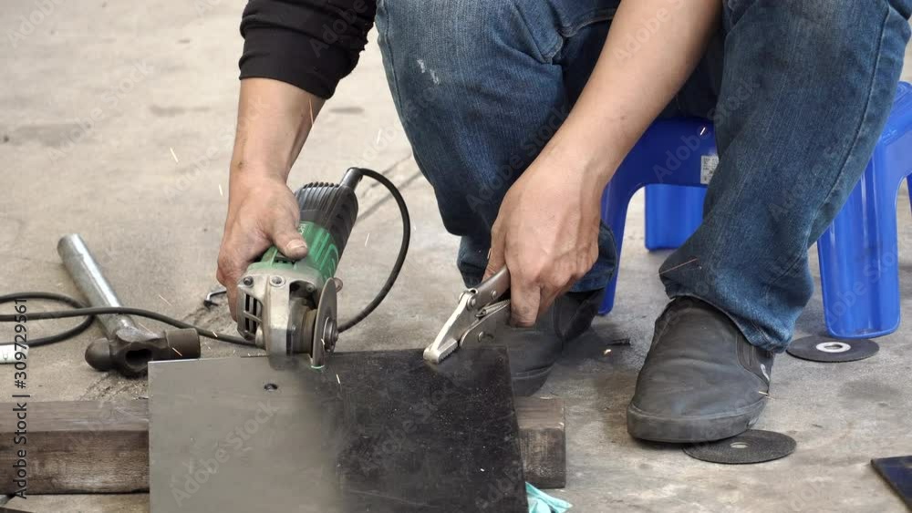 Male auto mechanic hand using angle grinder and adjustable spanner wrench for cutting steel plate from car part in auto repair garage. Automobile industry concept. 4K Video Male auto mechanic hand using angle grinder and adjustable spanner wrench for cutting steel plate from car part in auto repair garage. Automobile industry concept. 4K Video