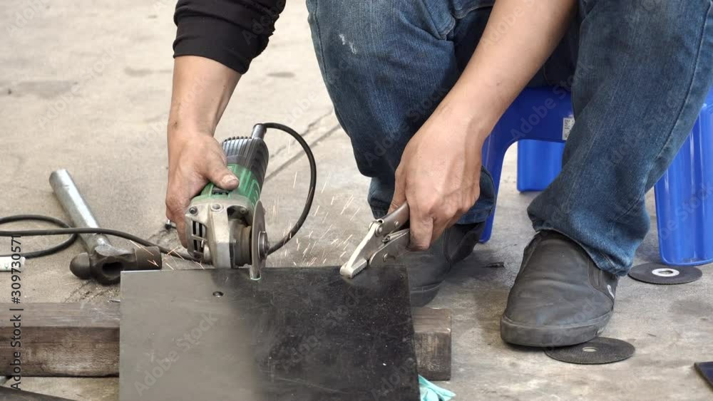 Male auto mechanic hand using angle grinder and adjustable spanner wrench for cutting steel plate from car part in auto repair garage. Automobile industry concept. 4K Video Male auto mechanic hand using angle grinder and adjustable spanner wrench for cutting steel plate from car part in auto repair garage. Automobile industry concept. 4K Video