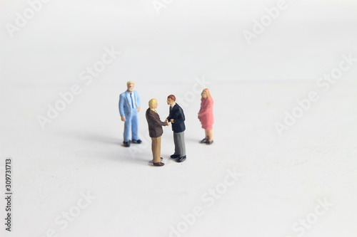 Gray Backgrond, Simple Illustration Photo for Mini Figure Two Man Toy Handshaking for Business Agreement Beyond their partner