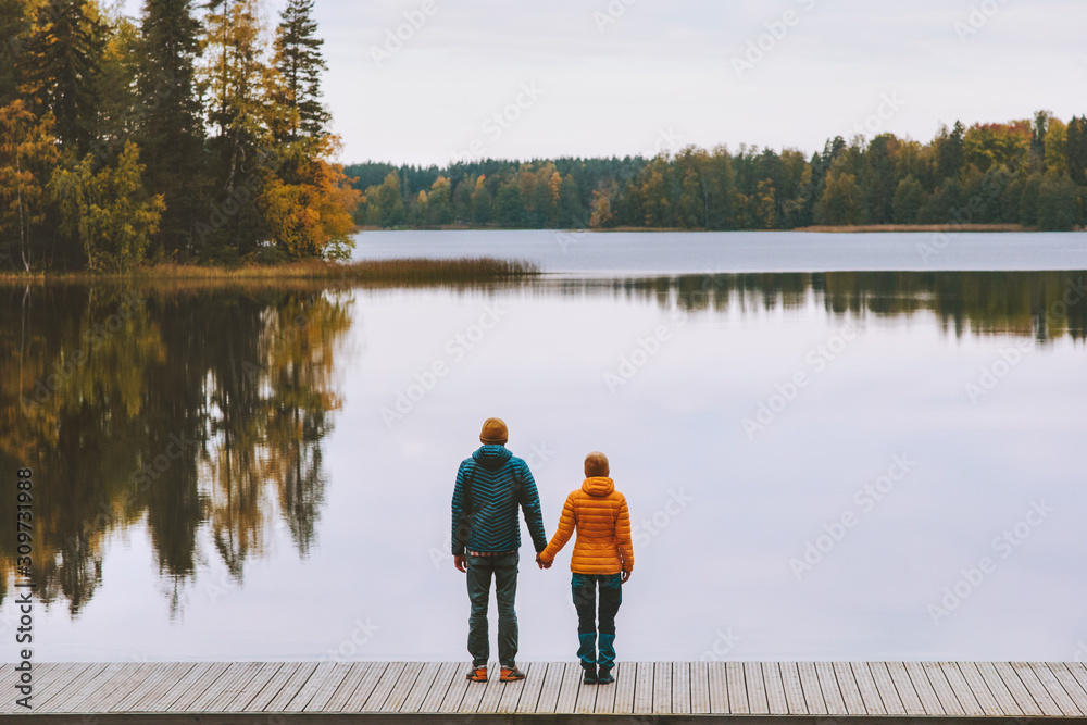 Couple in love holding hands romantic dating family lifestyle relationship man and woman standing on pier outdoor enjoying lake and autumn forest landscape