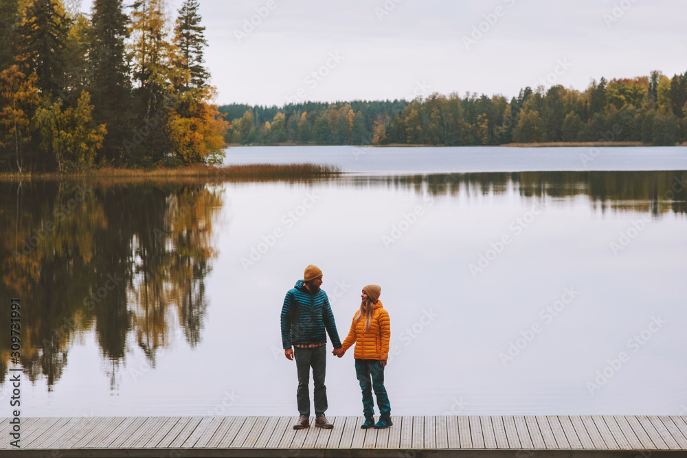 Couple in love holding hands walking travel family lifestyle romantic dating relationship man and woman standing on pier outdoor enjoying lake and autumn forest landscape in Finland