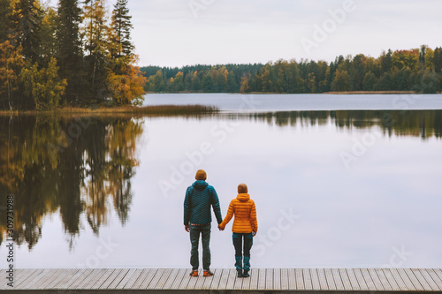 Couple in love holding hands romantic dating family lifestyle relationship man and woman standing on pier outdoor enjoying lake and autumn forest landscape