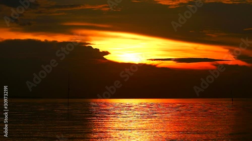 dark gold sunset silhouette hard light of orange cloud on evening sky over sea1 photo