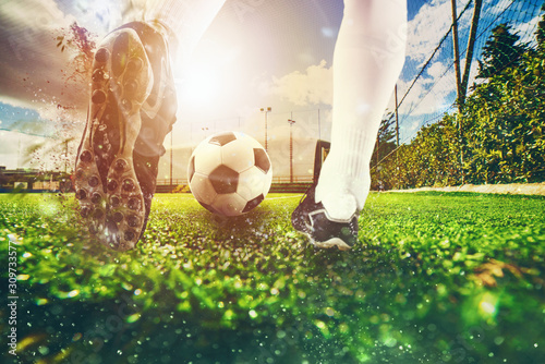 Close up scene at soccer field with a soccer shoe hitting the ball during training