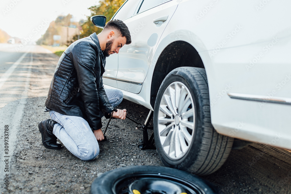 Bearded man, mechanic changing tire that are his car. Bearded man, mechanic changing tire that are his car.