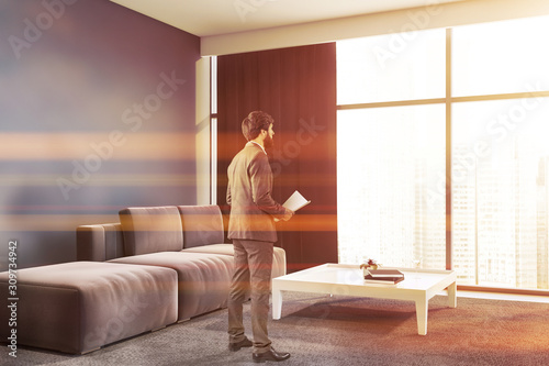 Man with documents in gray office lounge